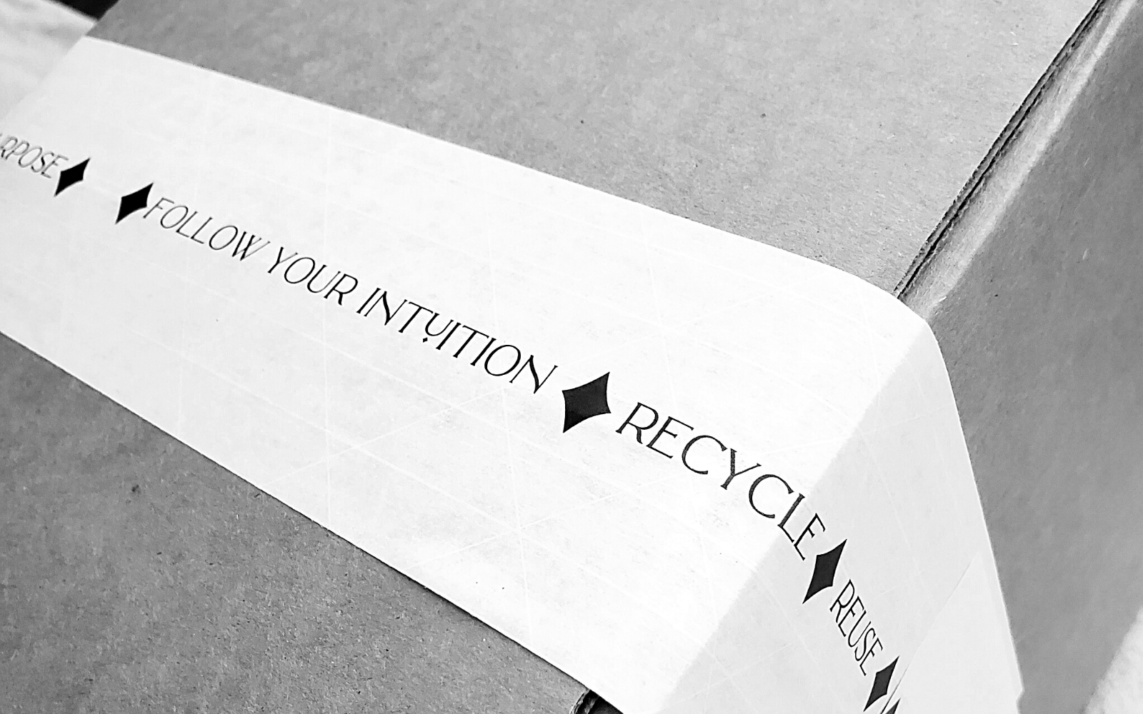 image of sustainable packaging in a recyclable box tapped with sustainable packing tape that says follow your intuition, recycle, reuse, repurpose.