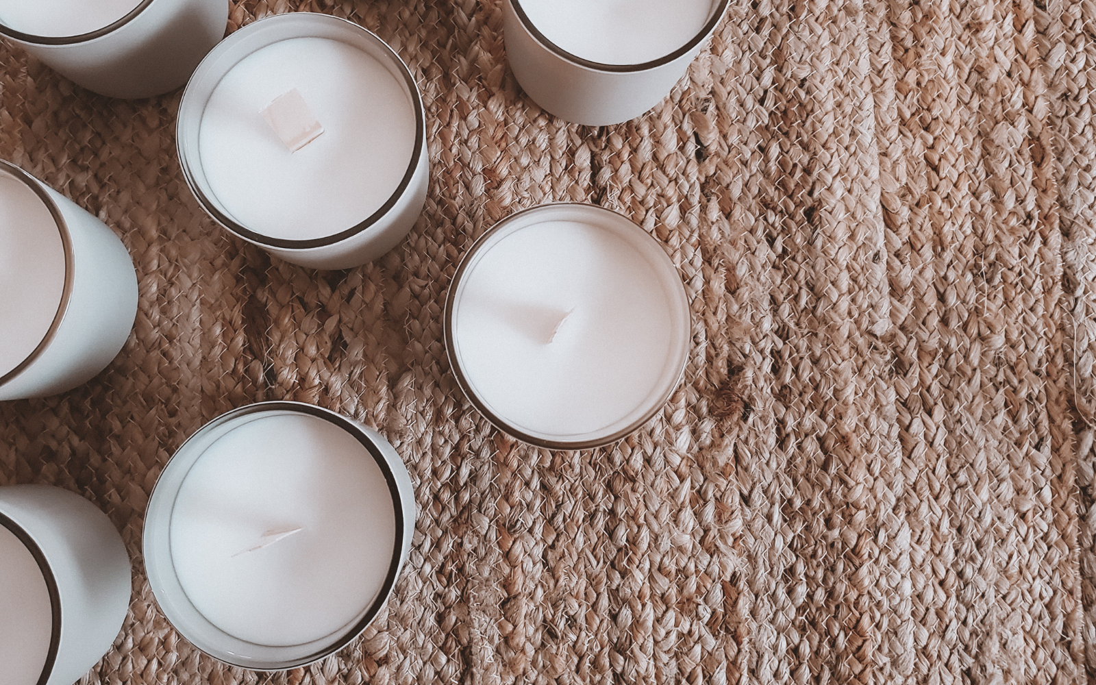 image of wooden wicks  candles sitting on a jute rug