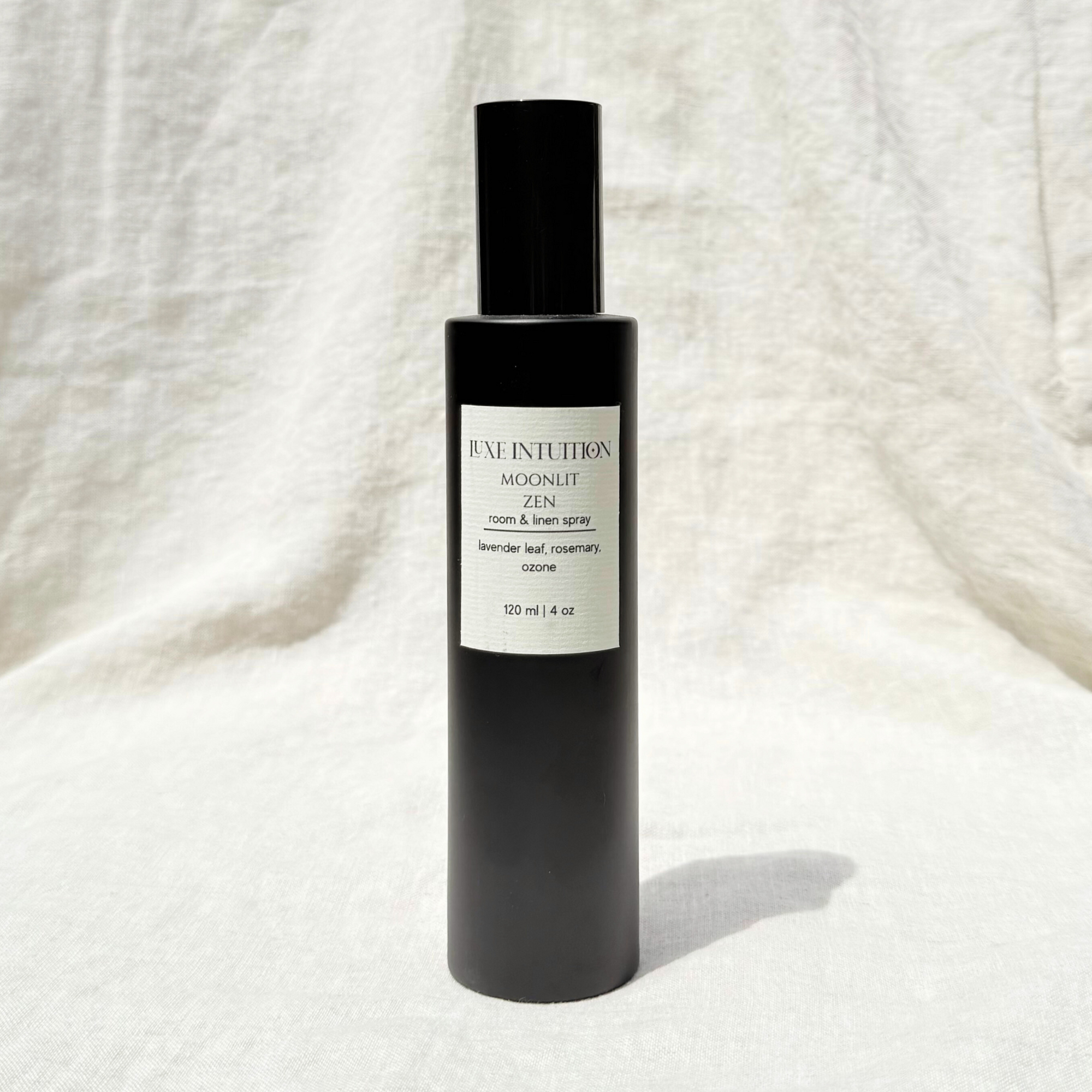 Lavender scented room and linen spray in a black spray bottle on a linen background
