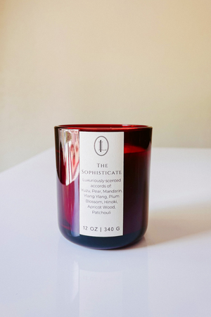 The Sophisticate Wooden Wick Candle in a translucent wine colored jar