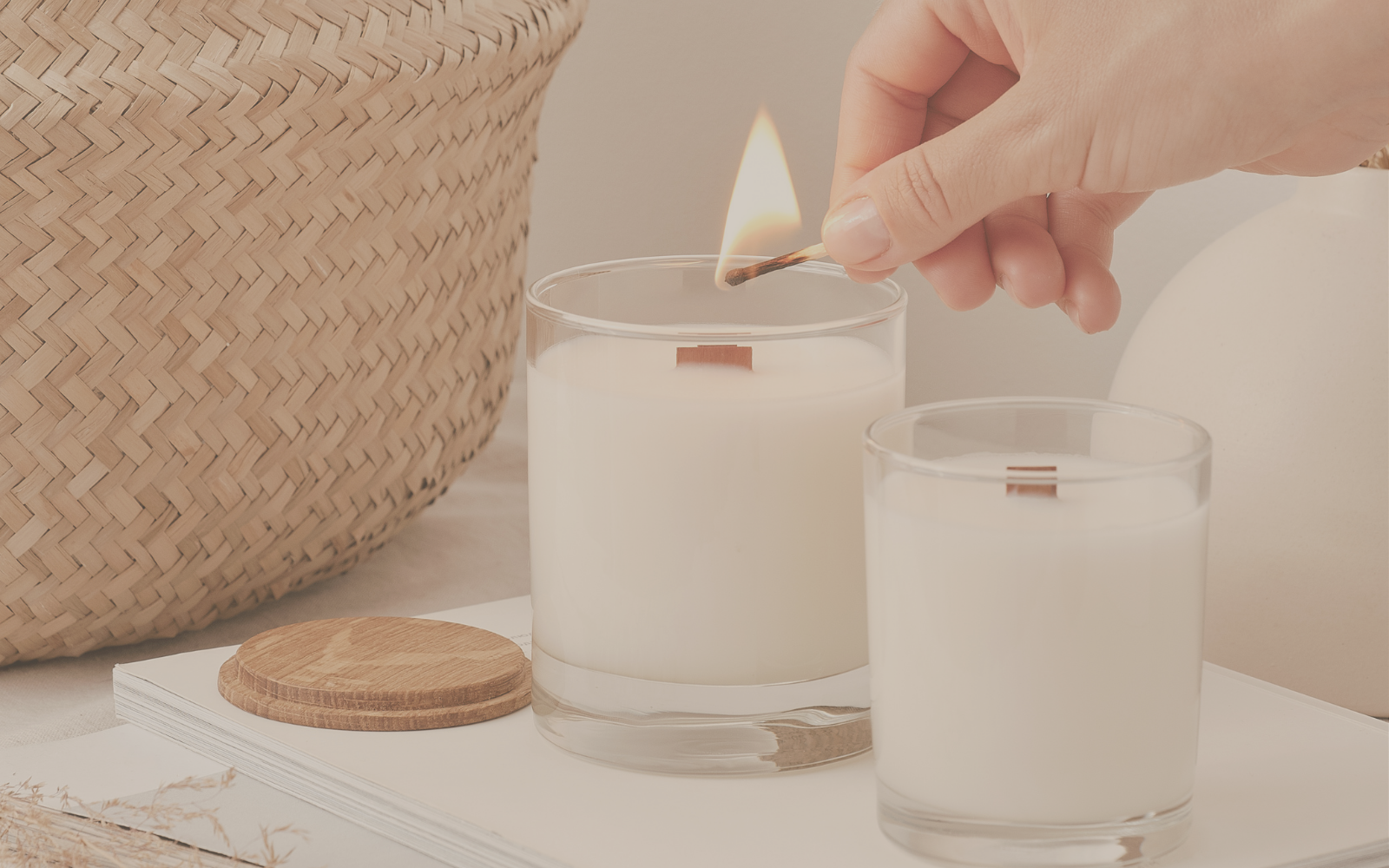 image of person lighting a wooden wick candle with a match